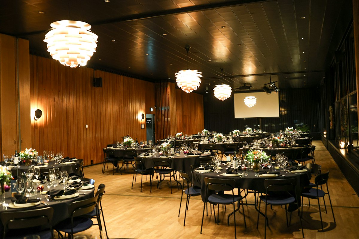 Elegant event venue set with round tables for a corporate summit Elegant event venue set with round tables for a corporate summit
