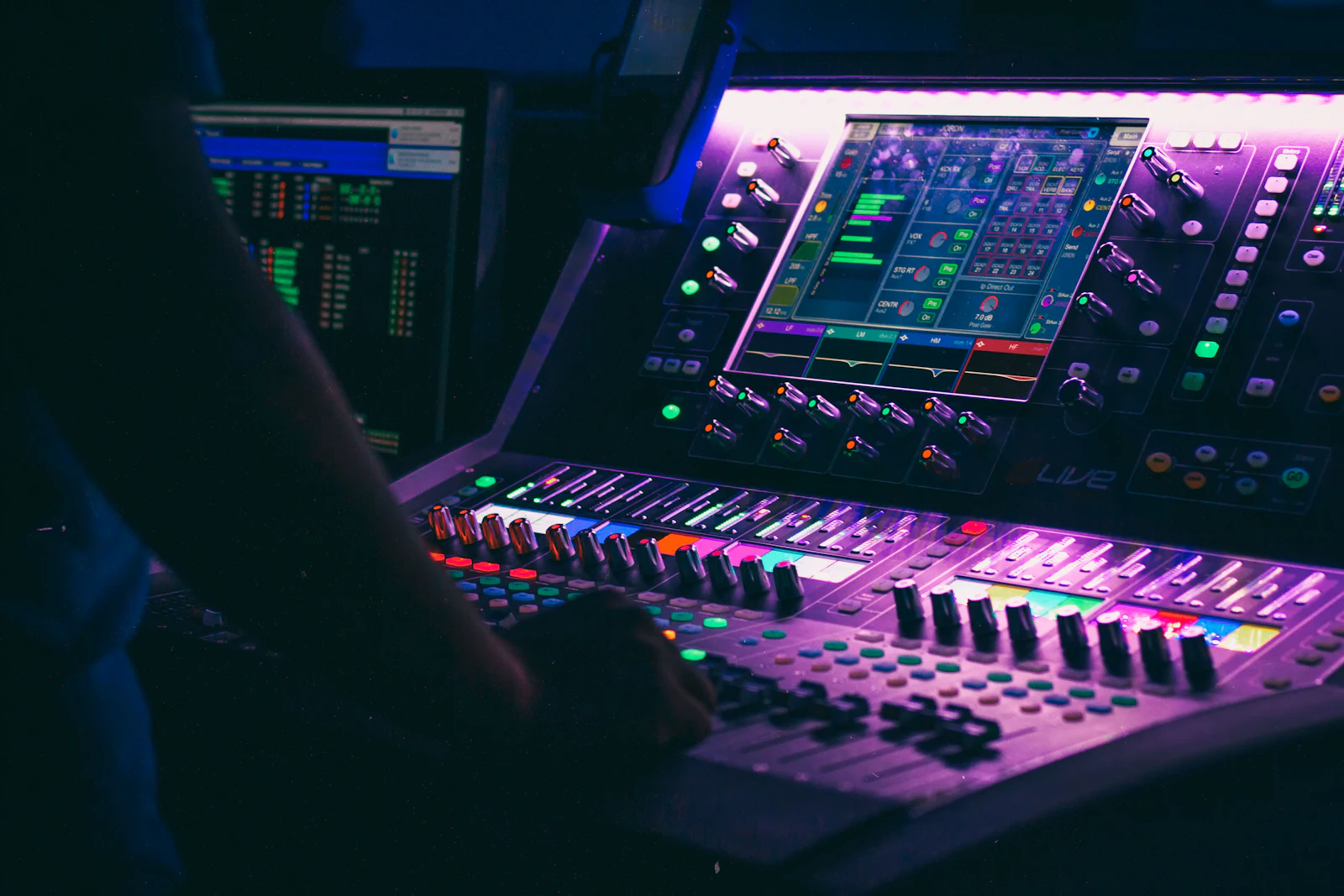 Sound engineer operating a digital mixing console during a live concert