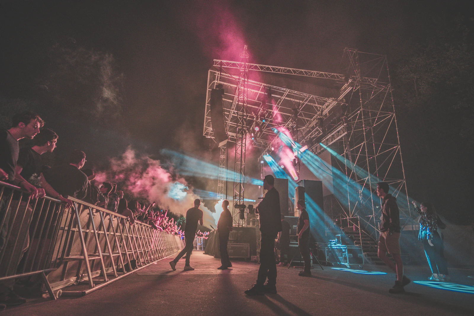 Concert stage rigging with steel truss towers and crowd barriers