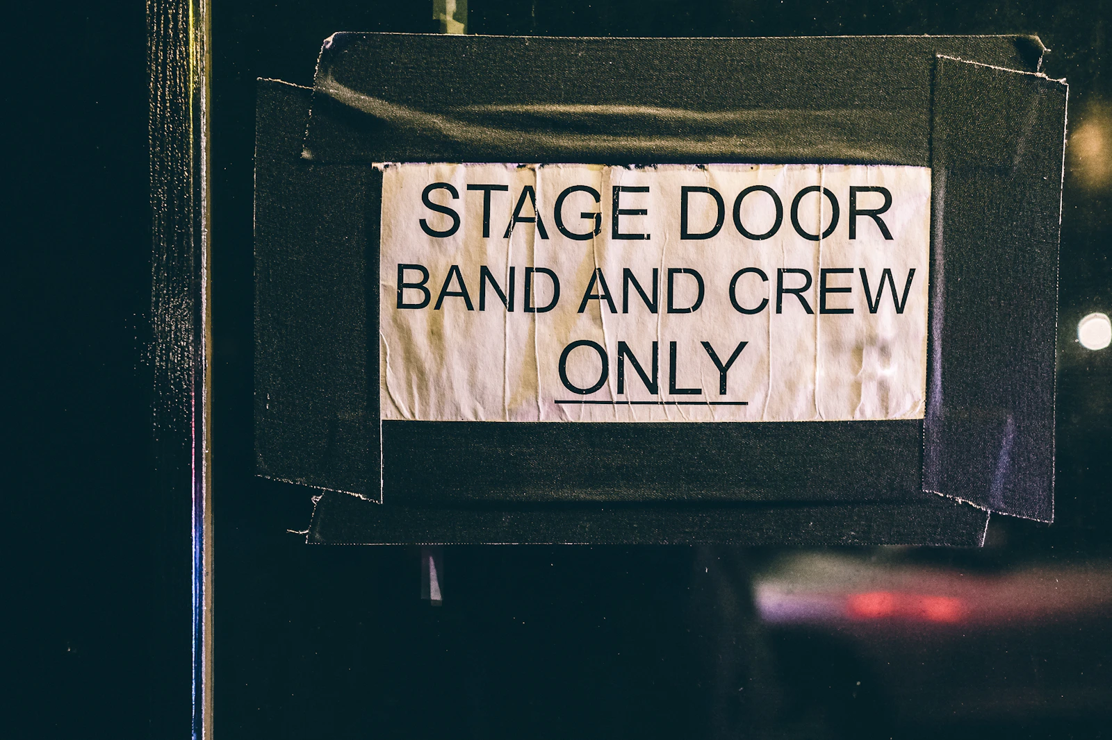 Backstage stage door sign reading band and crew only at a concert venue