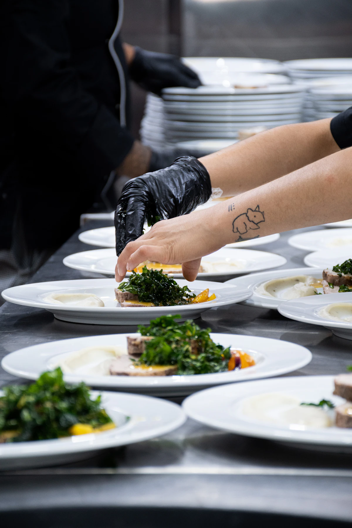 Catering team plating dinner courses for gala dinner guests