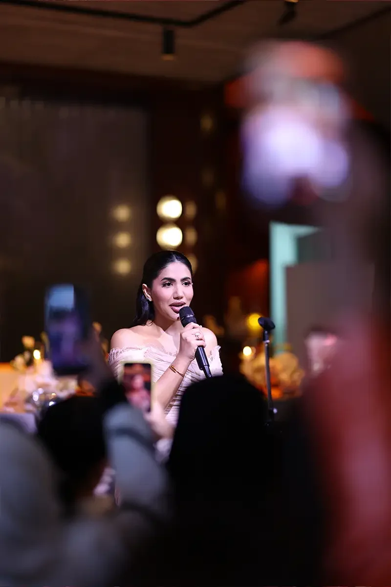 Speaker addressing guests with a microphone at a private fragrance launch in Dubai
