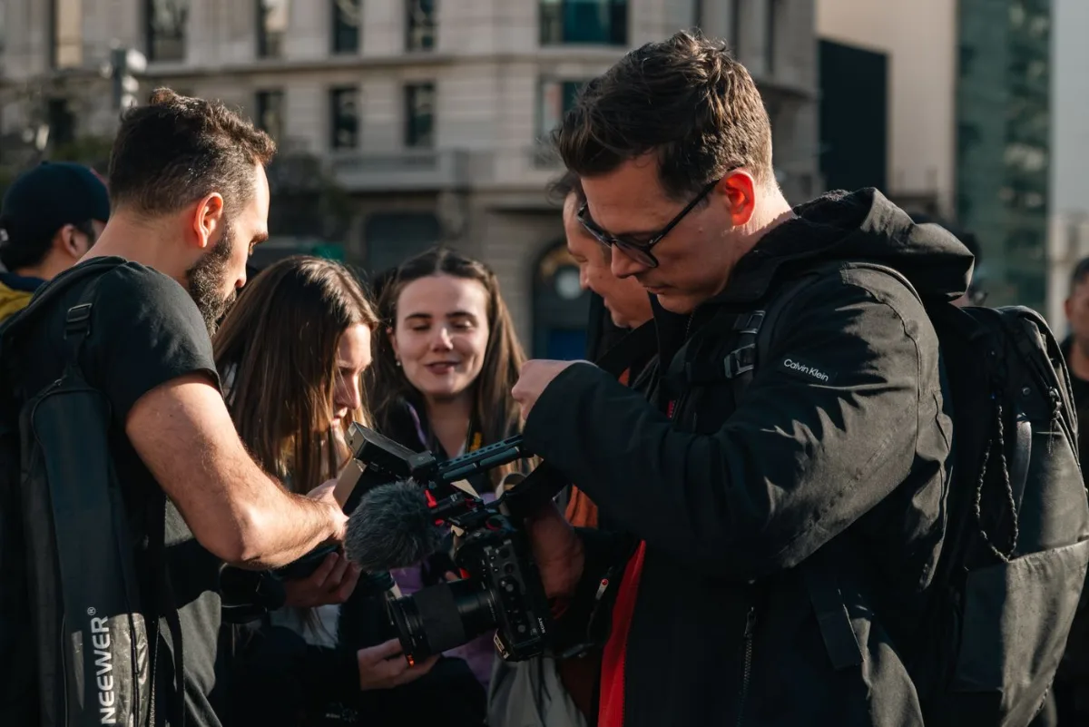 Film crew reviewing commercial footage on set and discussing revisions