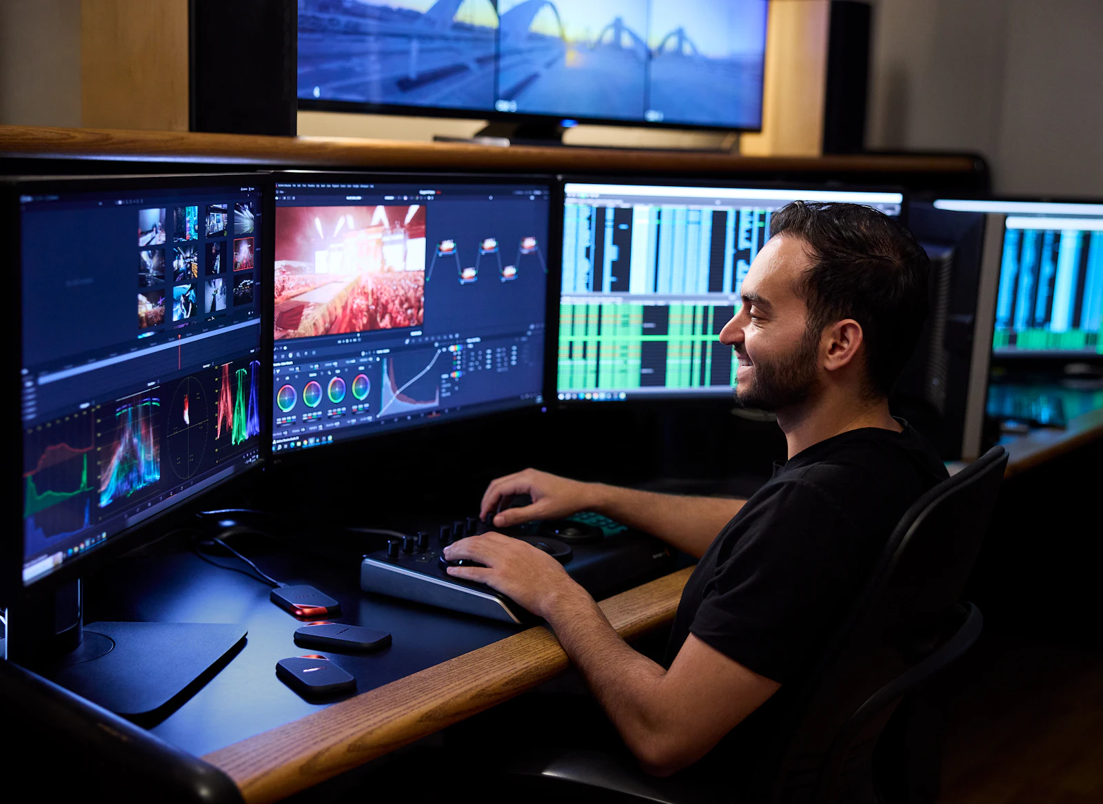 Video editor comparing commercial revisions across multiple monitors in an edit suite Video editor comparing commercial revisions across multiple monitors in an edit suite